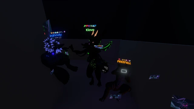 My POV of four avatars in a dark staircase corner with emissive parts. One of them is doing a gesture to take a picture of me.